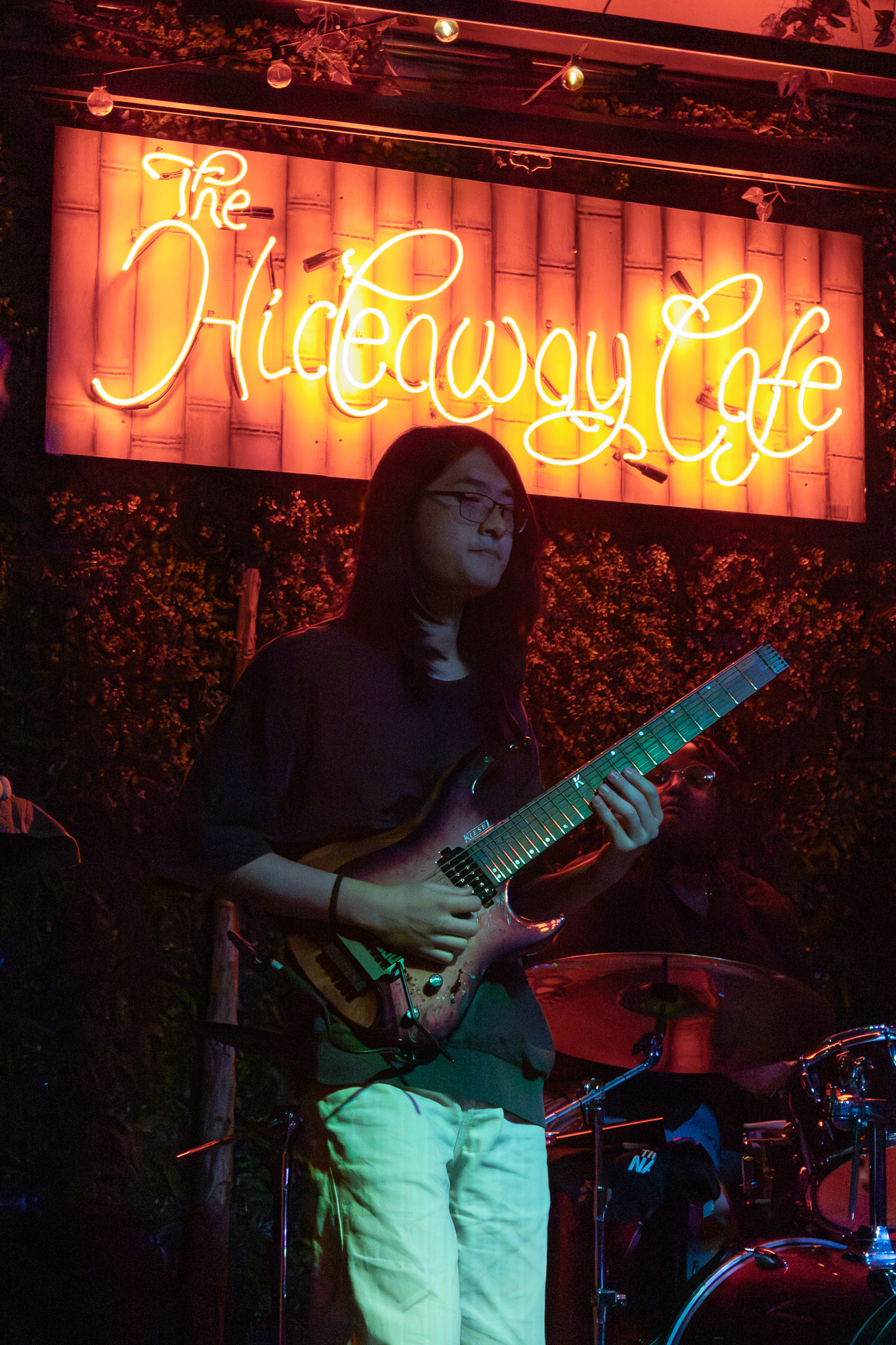 Guitarist under neon sign